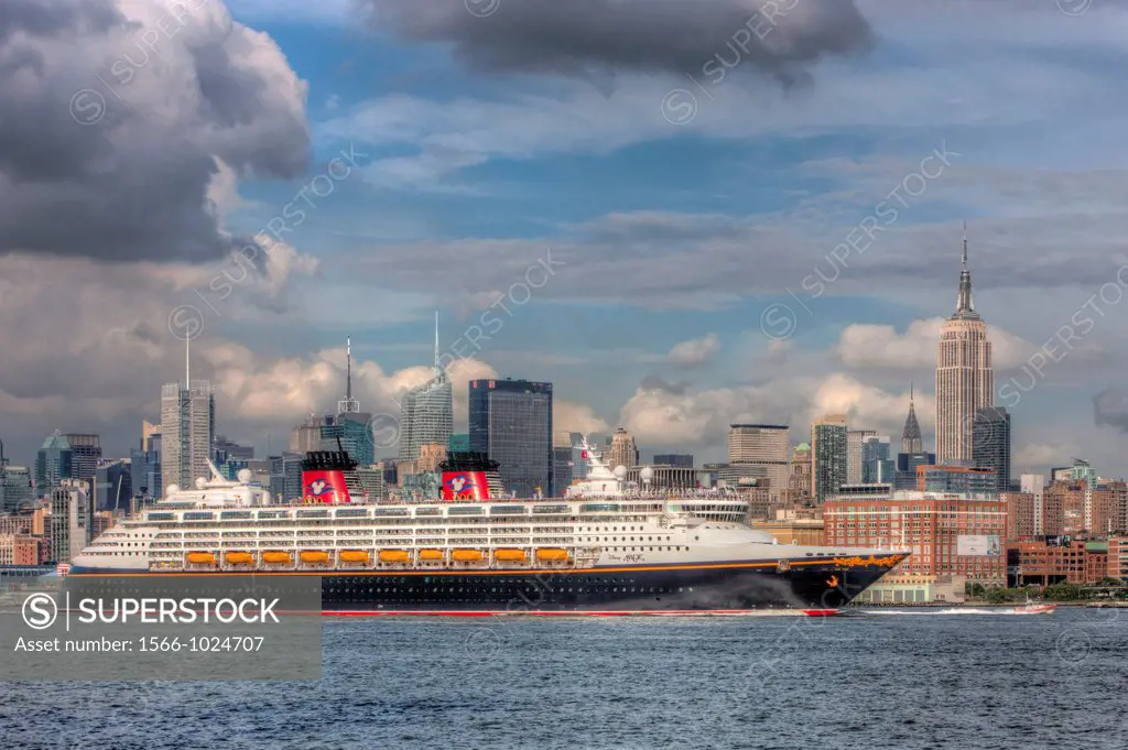 Disney Cruise Line cruise ship Disney Magic heads south on the Hudson River past the New York City skyline, under threatening skies, after departing t...