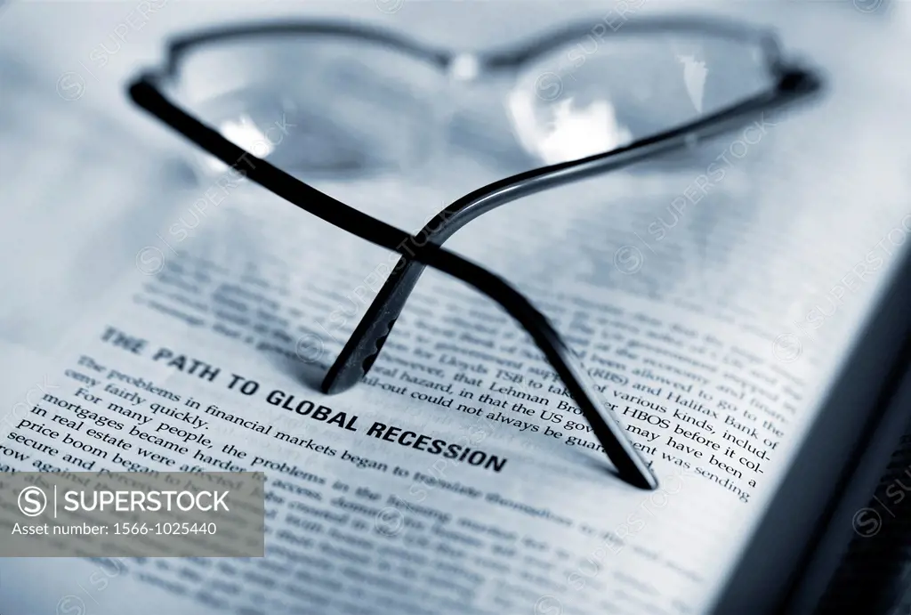 economy handbook, science book about global recession, with glasses on out of focus