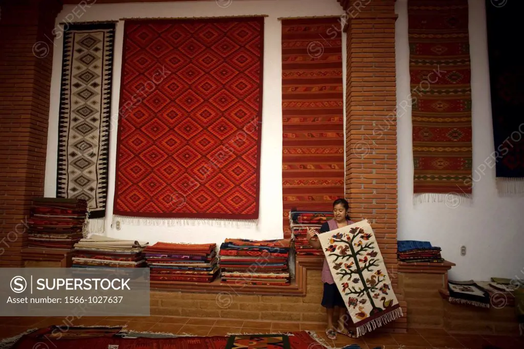 A woman shows a carpet in a weaving studio of Teotitlan del Valle, Oaxaca, Mexico