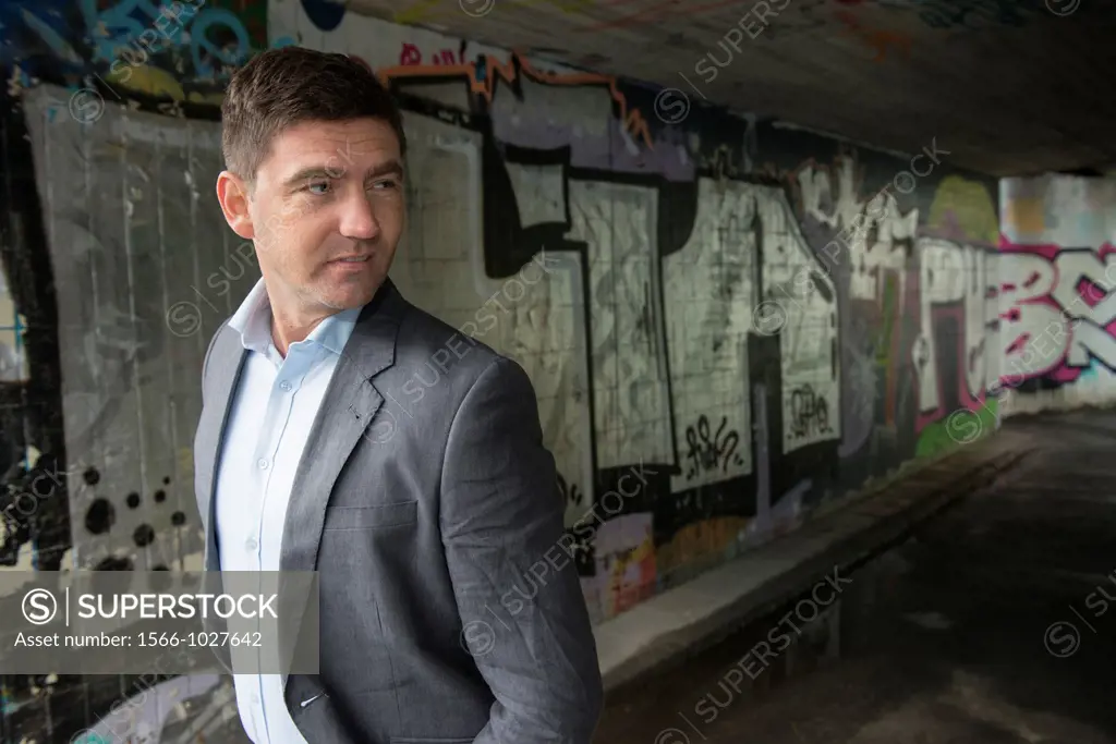 Portrait of a businessman in a walkway covered with grafitti