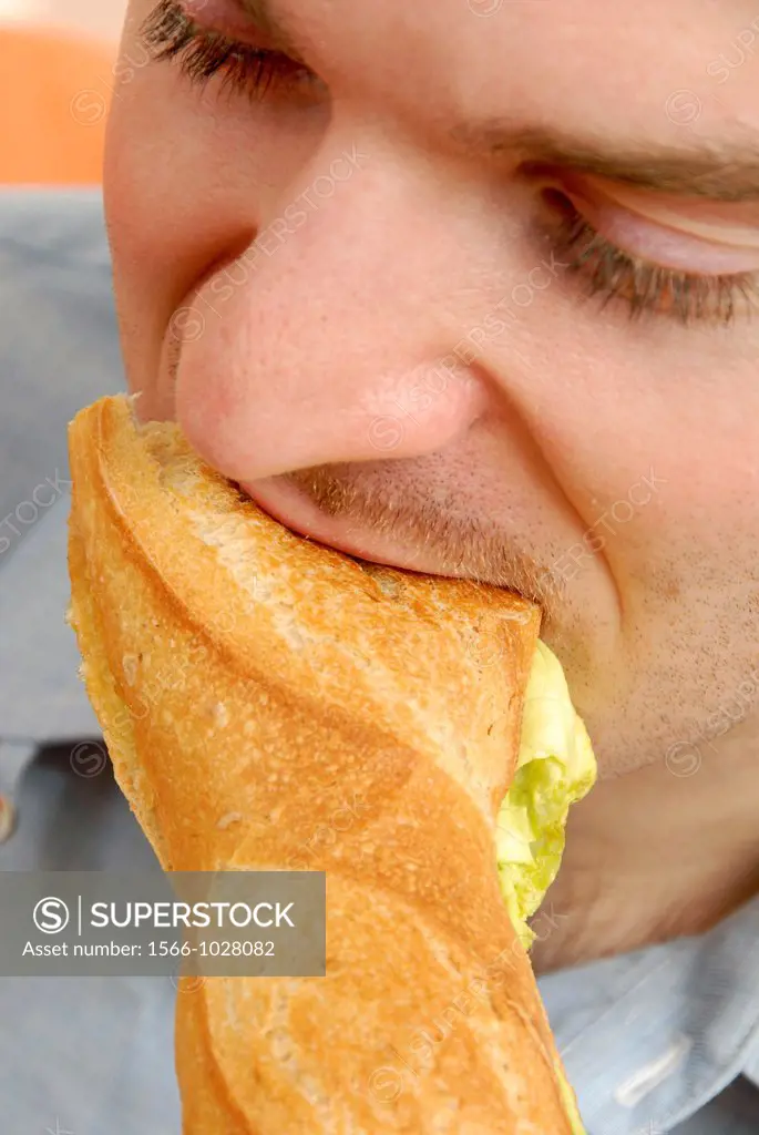 25 year old man eating a sandwich for lunch