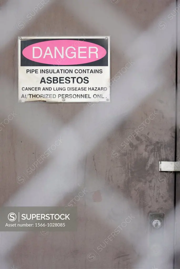 Asbestos warning sign on door at an abandoned factory building, North Carolina, USA
