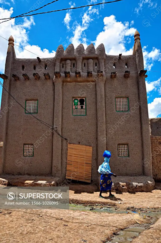 Woman passing by a Sahel style building. Djenne, Mali