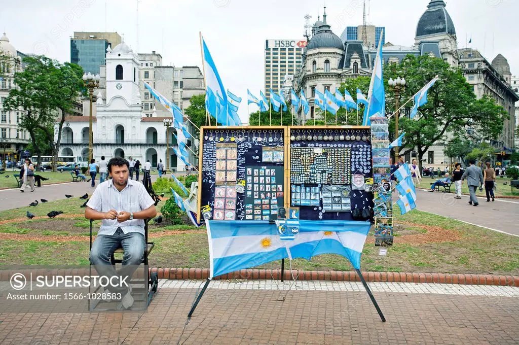 Man selling argentinian flags on a stall, Plaza de Mayo, Buenos Aires, Argentina.