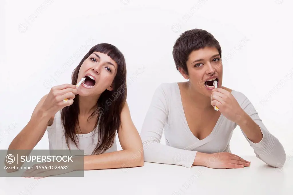 Two women brushing teeth