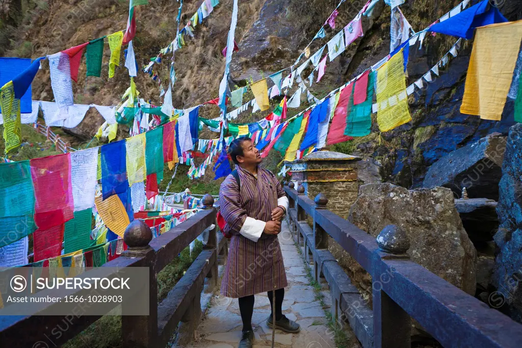 Bhutanese man crossing the bridge to the Taktsang Monastery Tiger´s Nest, Paro Valley, Bhutan, Asia.