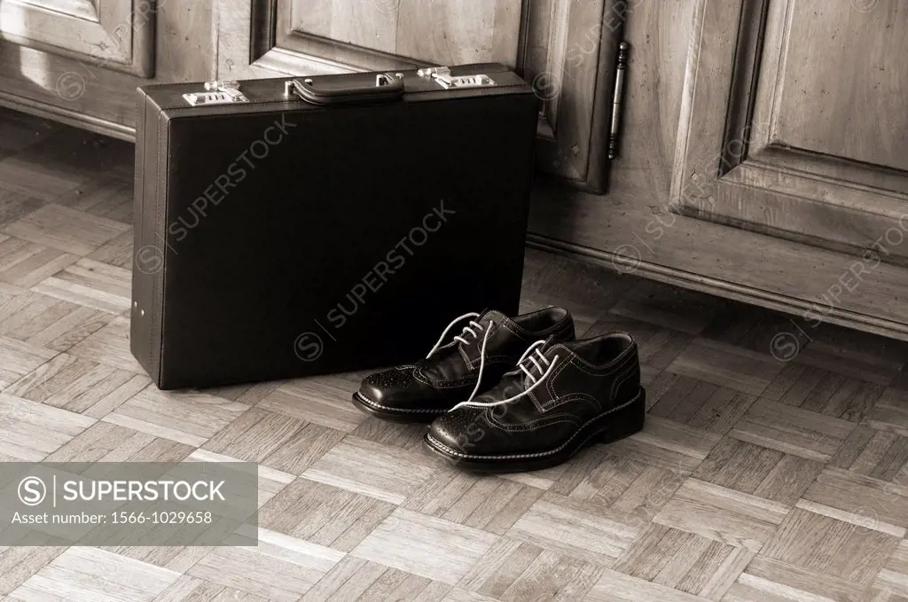 men´s black shoes next to briefcase, on the wooden floor, home, after work private life