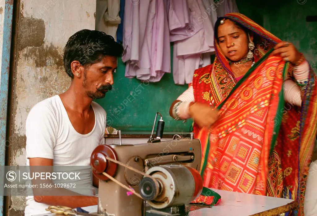 Tailor with a client. Rajasthan, India. The client is a woman belonging to the Rebari caste.