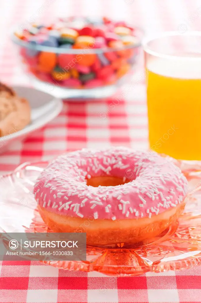 Donut with sprinkles and a glass of orange soda