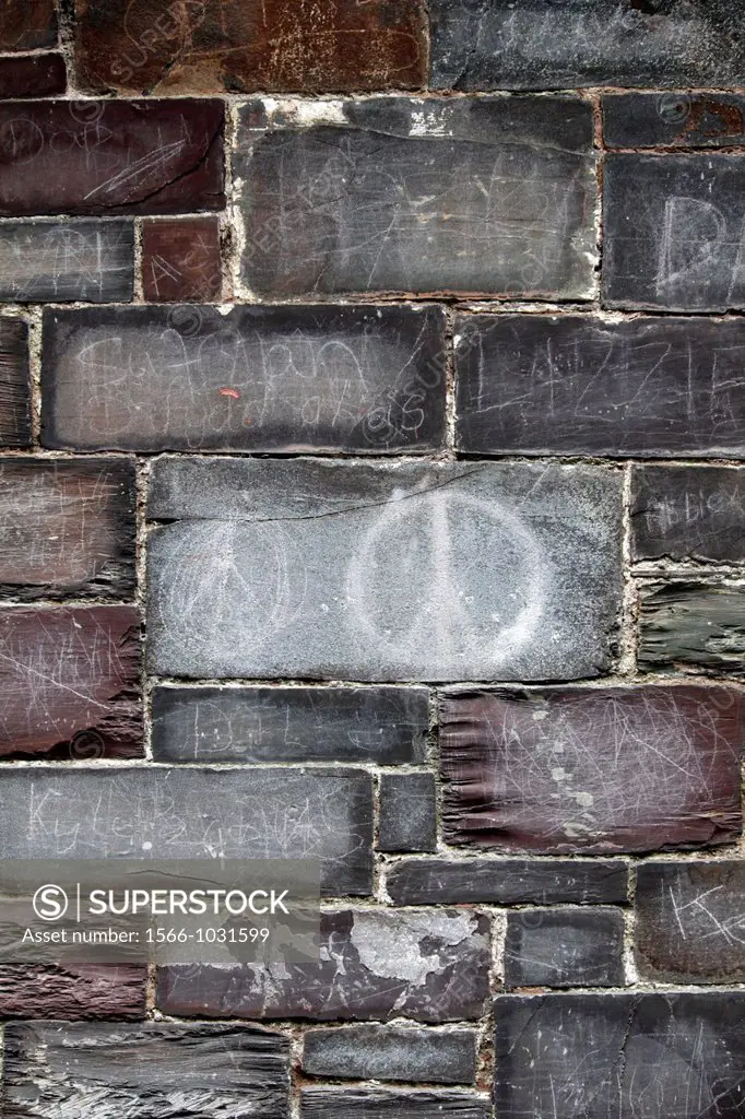 peace symbol and graffiti on slate wall