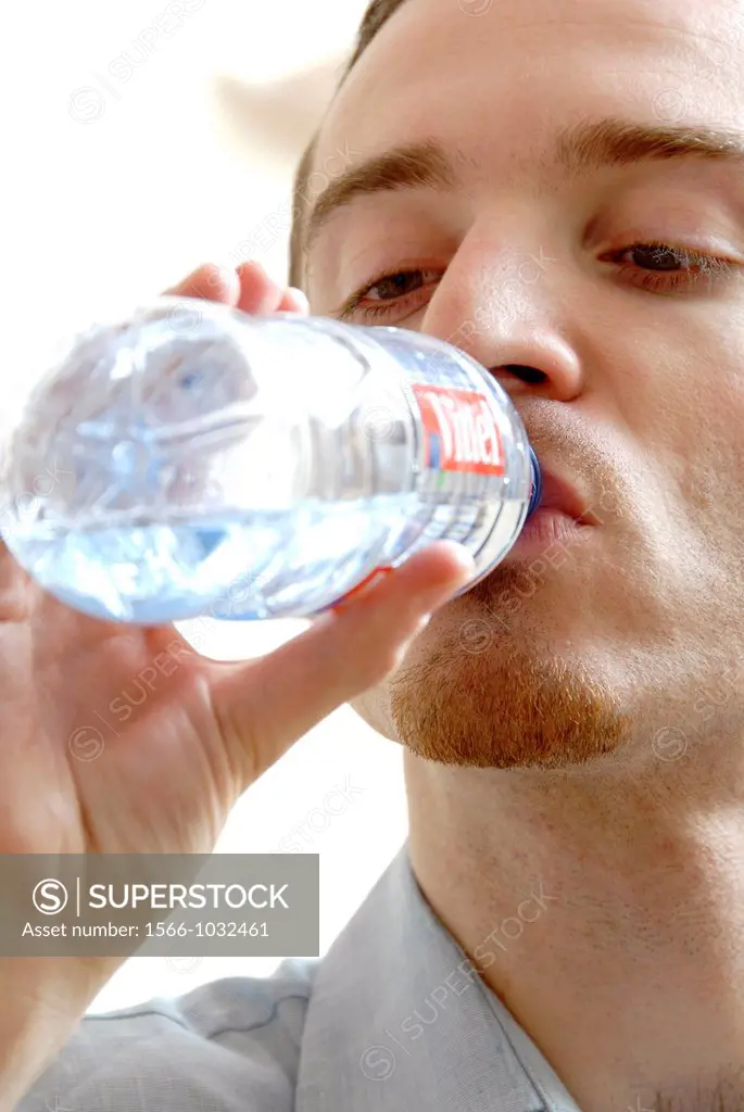 25 years old man drinking mineral water
