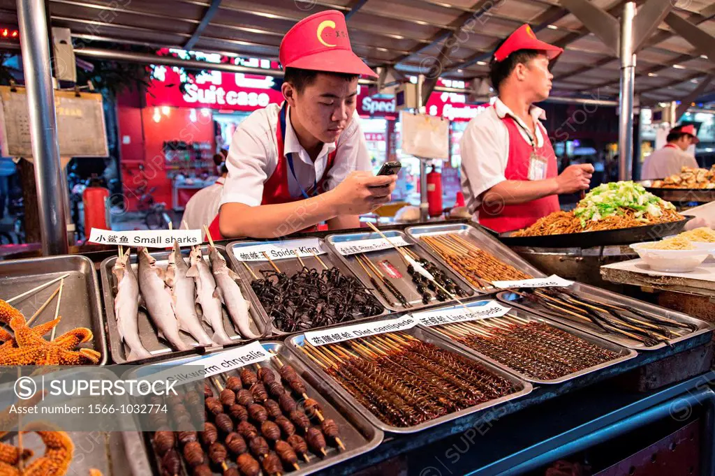 Street vendor selling exotic foods at the night food market along Wangfujing Street shopping district in Beijing, China