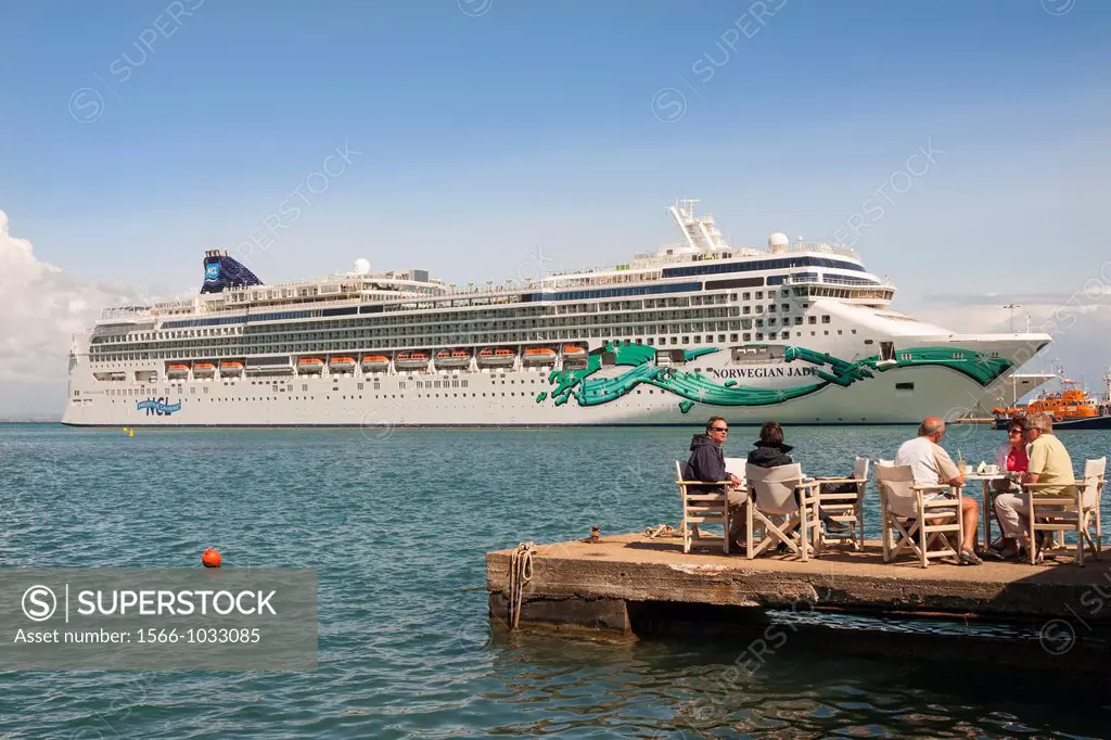 Tourists dining alfresco in front of the Norwegian Jade cruise ship, Katakolon, Greece