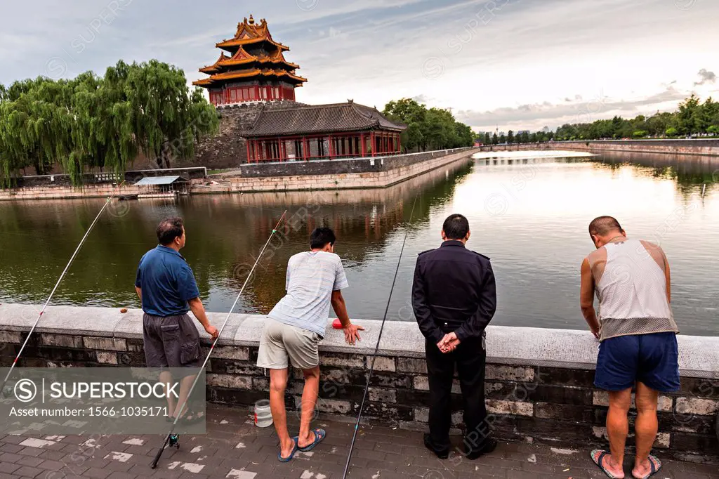Beijing residents fish along the moat near the Arrow Tower on the palace walls of the Forbidden City during a summer evening in Beijing, China