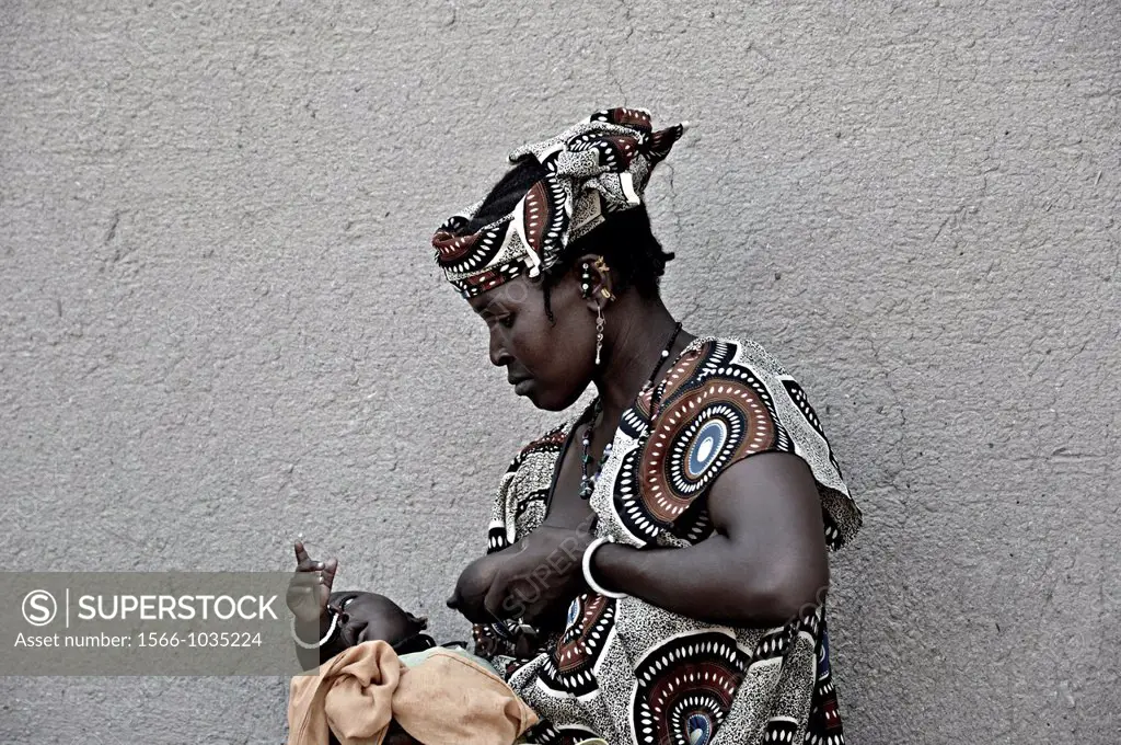 Woman preparing to breastfeed her baby, Djenne, Mali