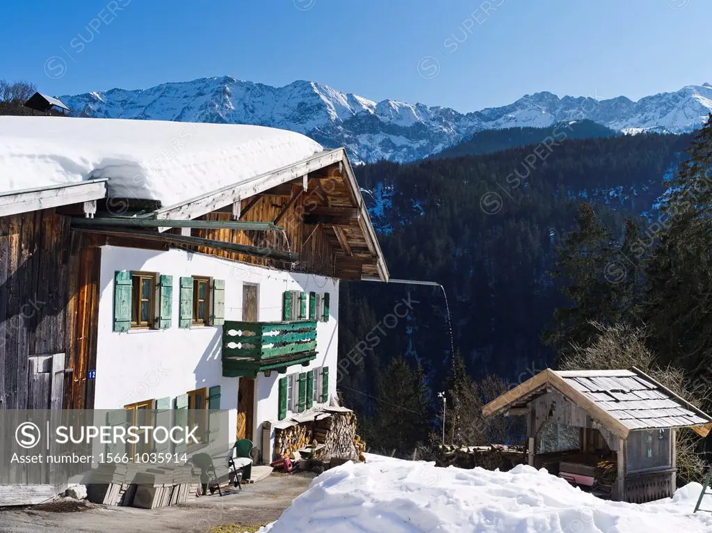 Traditional mountain farm in the village of Graseck in the Wetterstein Mountain Range during winter The Wetterstein Mountain Range includes Mount Zugs...