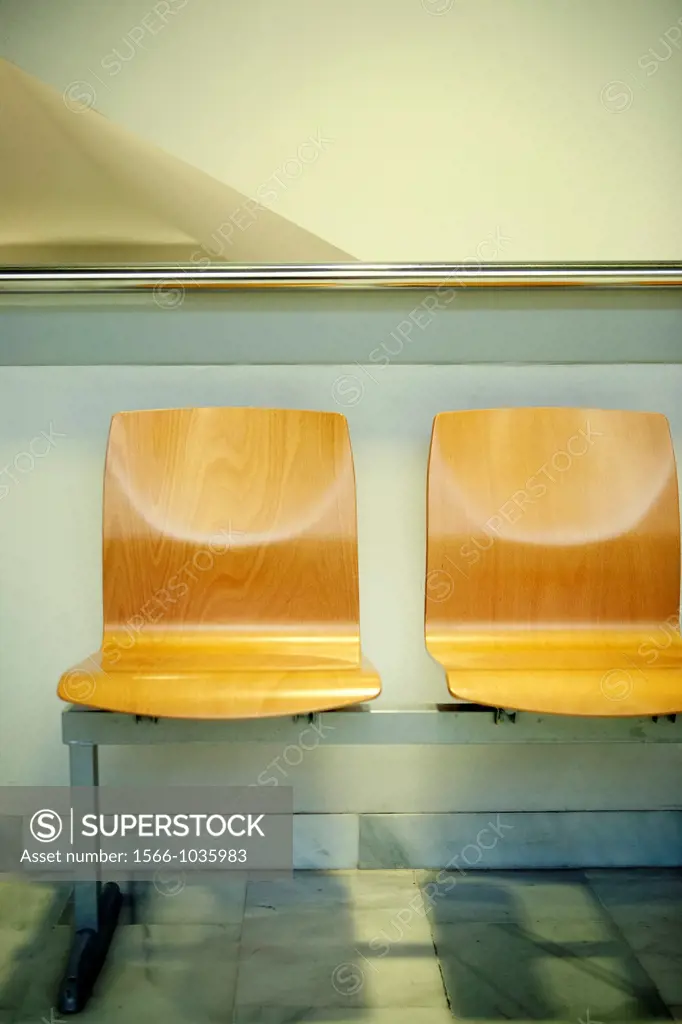 Two wooden chairs in a waitroom