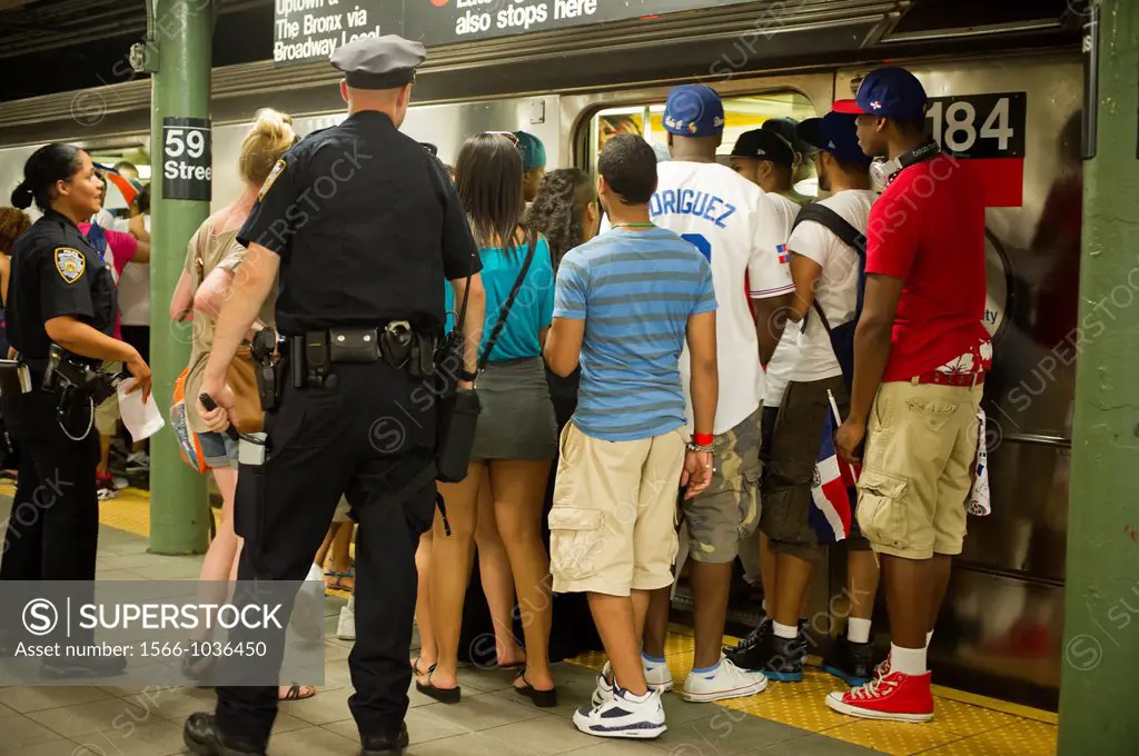 Revelers crowd the Number One subway train at the Columbus Circle station, traveling up to Washington Heights, after the Dominican Day parade in New Y...