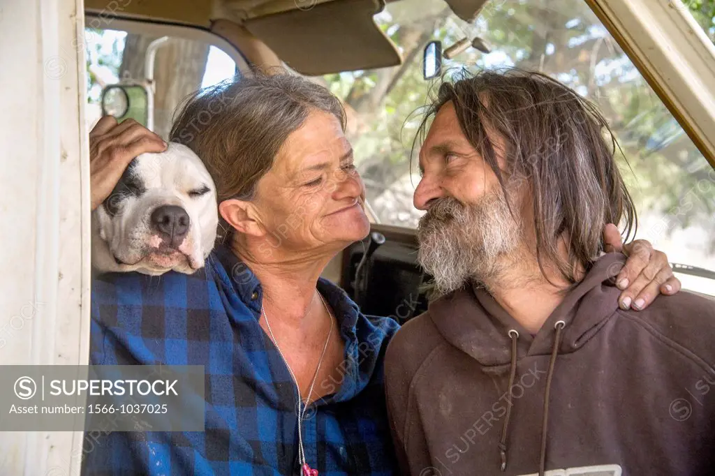 An affectionate indigent couple and their dog live in a truck camper among homeless residents of a primitive outdoor encampment in the desert town of ...