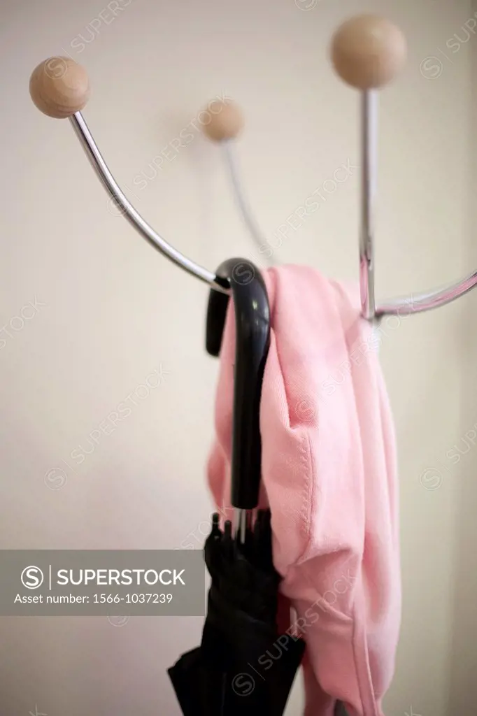 Pink cardigan and umbrella on a rack