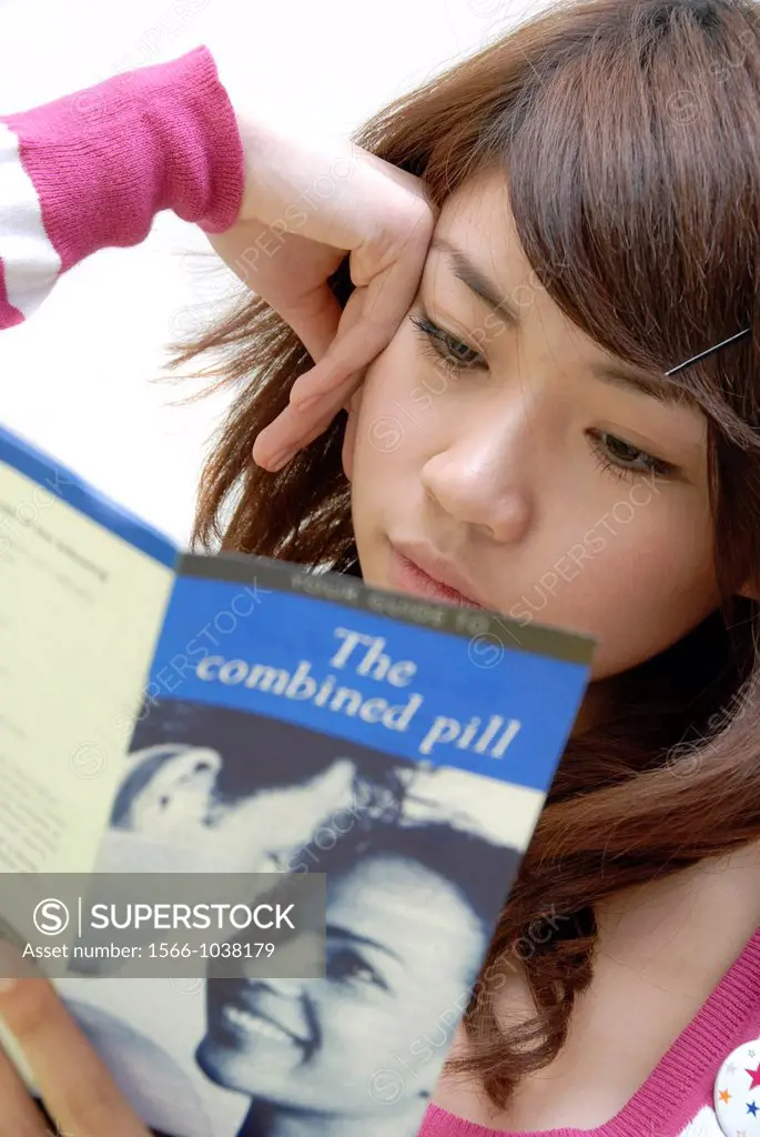 Young woman reading a leaflet about oral contraception