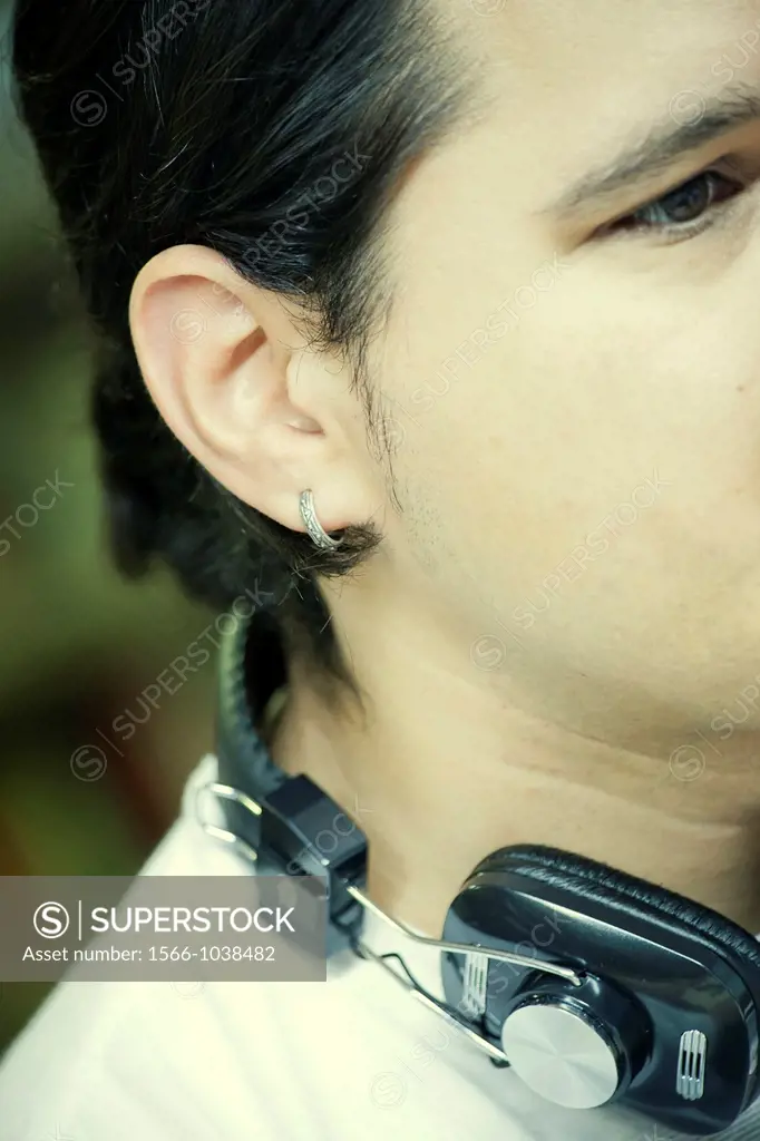 Young man with earphones and earring