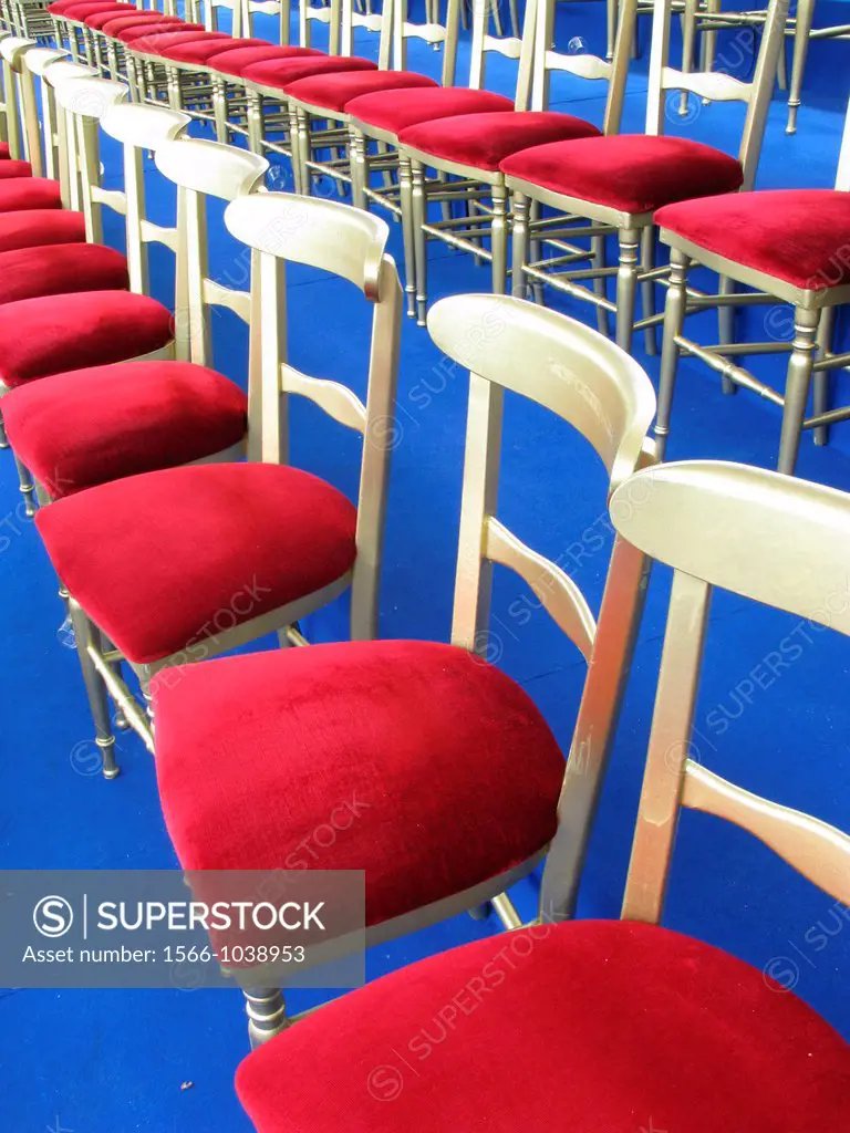 rows of red gold chairs for vip at an outdoor parade event