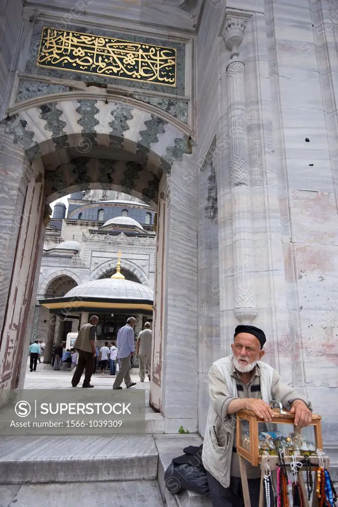 Old man selling small souvenirs at mosque entrance at Istanbul