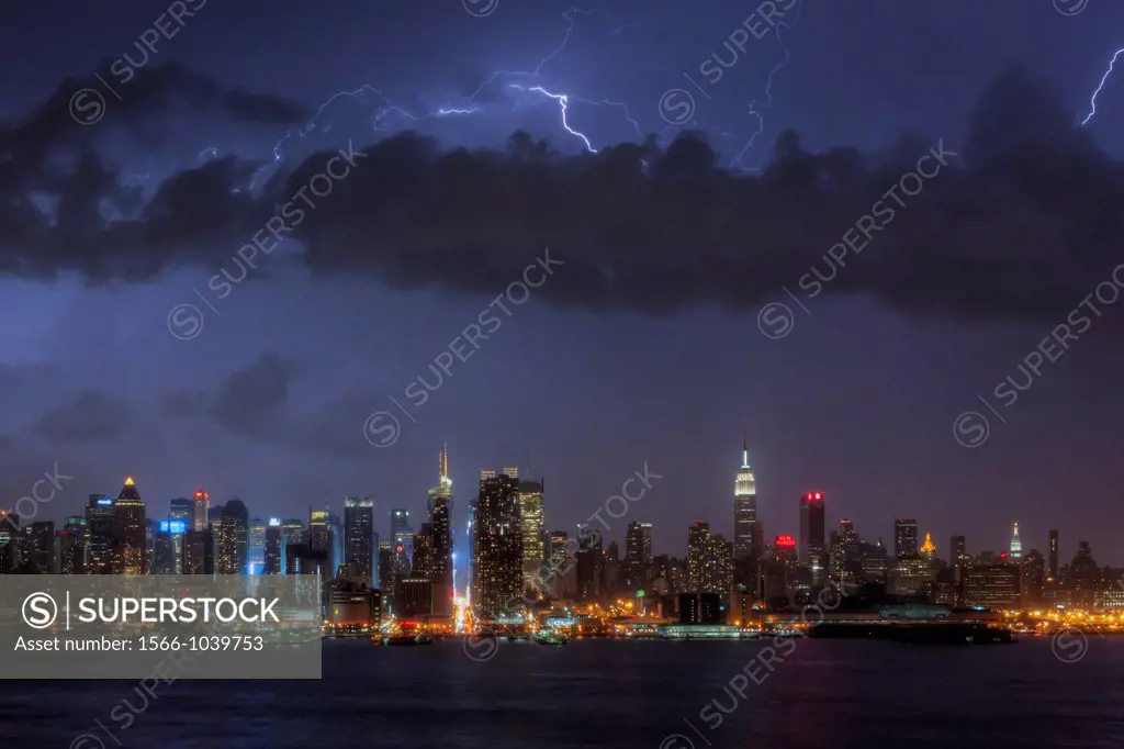 Lightning bolts illuminate the night sky over the skyline of New York City, New York, USA during a summer thunderstorm on Sunday, July 15, 2012