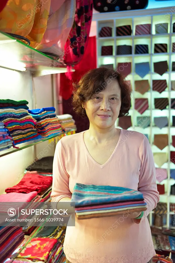 A shop owner shows off silk at the Nunal Boutique silk shop in Hanoi that sells colorful pieces of embroidered silk