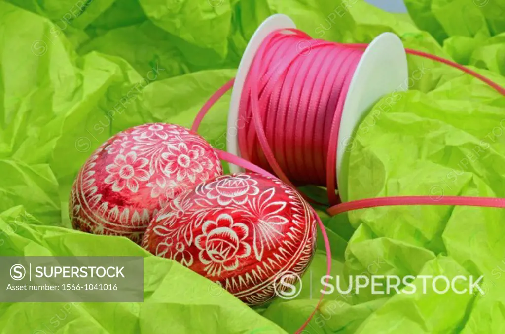 Colored Easter Eggs with Ribbon on green Background