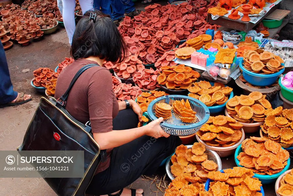 A lady selecting clay diwali diya,Poona,Maharashtra,India