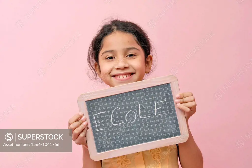 12 years old girl holding a board with school in frecn written on it