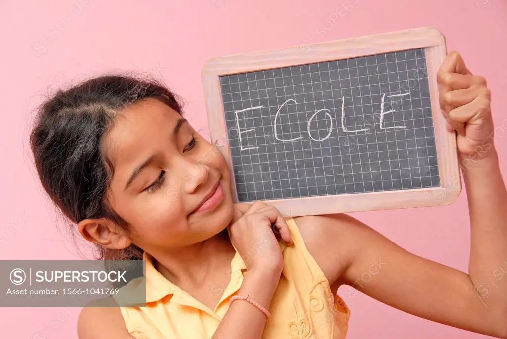 12 years old girl holding a board with school in frecn written on it