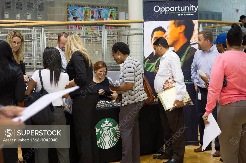 Job seekers queue up at a Starbucks table at a job fair in the East Harlem neighborhood of New York The job fair is one of the many events occurring d...