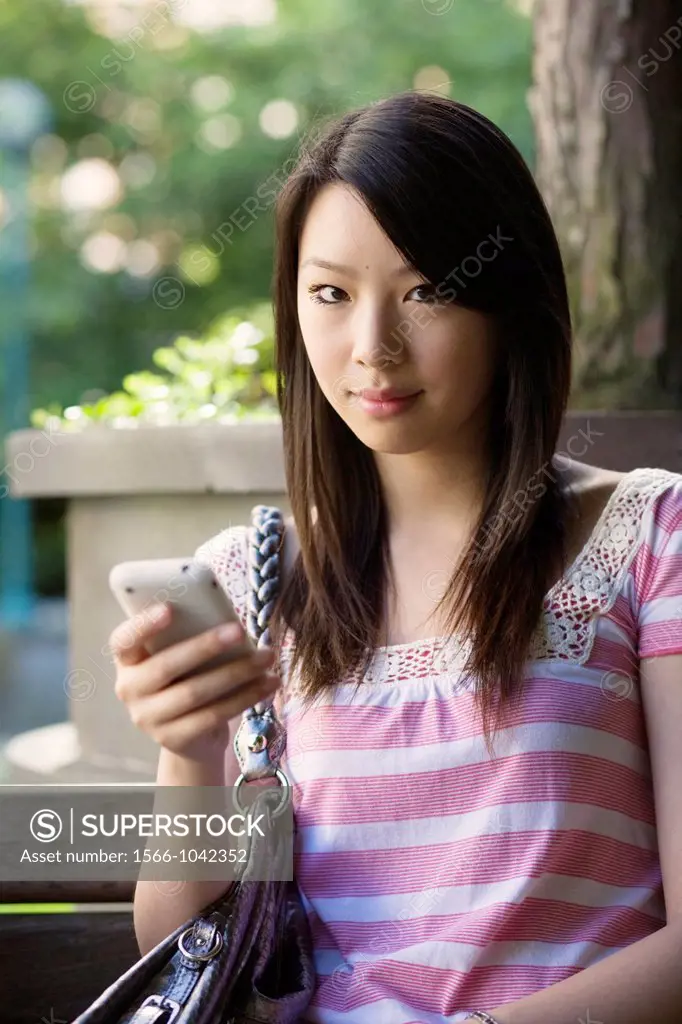 A portrait of a young woman texting on her mobile phone