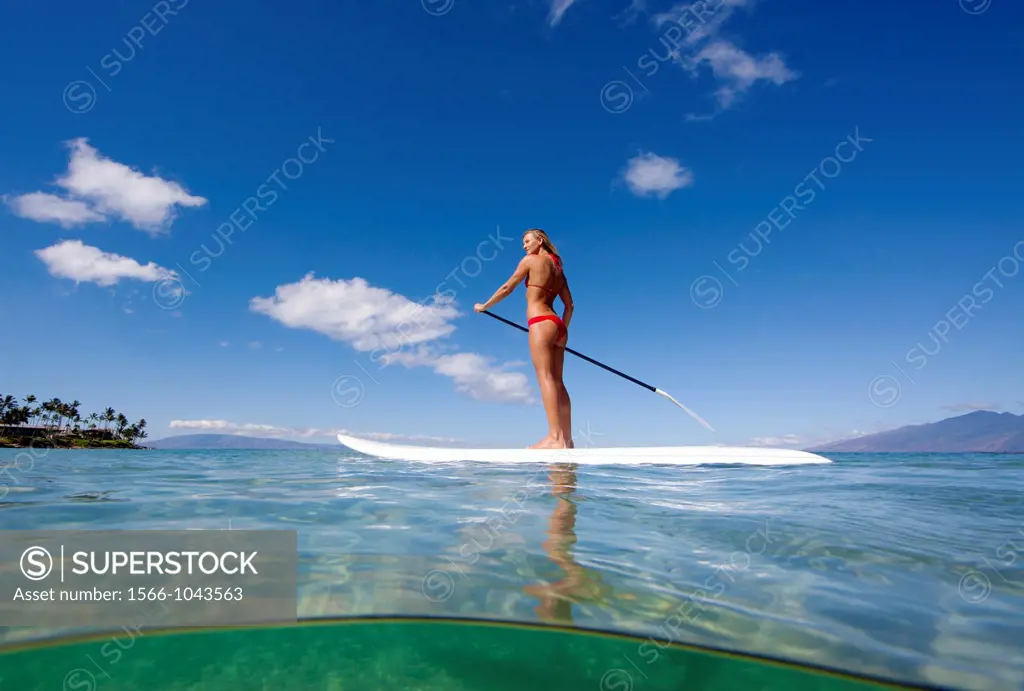 Healthy Maui girl stand-up paddles at Napili Bay, Maui, Hawaii
