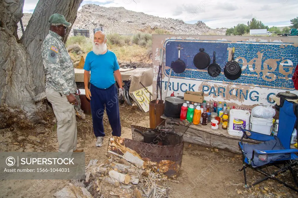 A uniformed African-American U S Army reservist offers a homeless military veteran information on Veterans Administration free medical care at an outd...