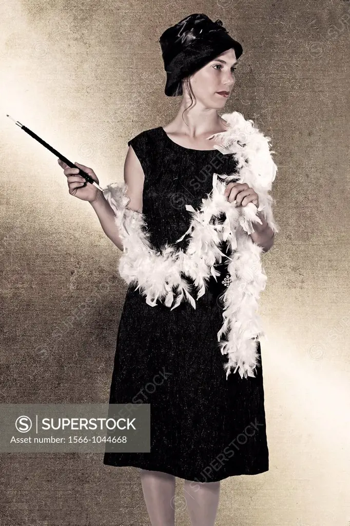 a woman in a black dress with a feather boa and cigarette holder