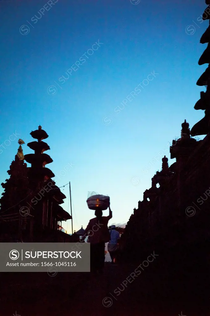 People carrying offering baskets on their head at The Ulun Danu Batur Temple on Mount Batur