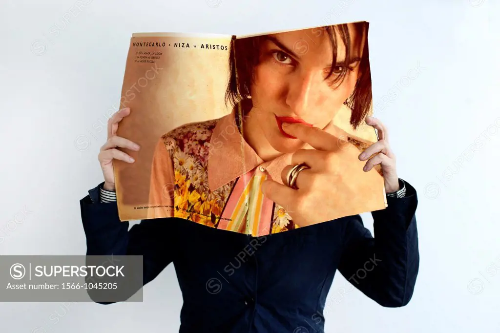 Woman covering her face with magazine