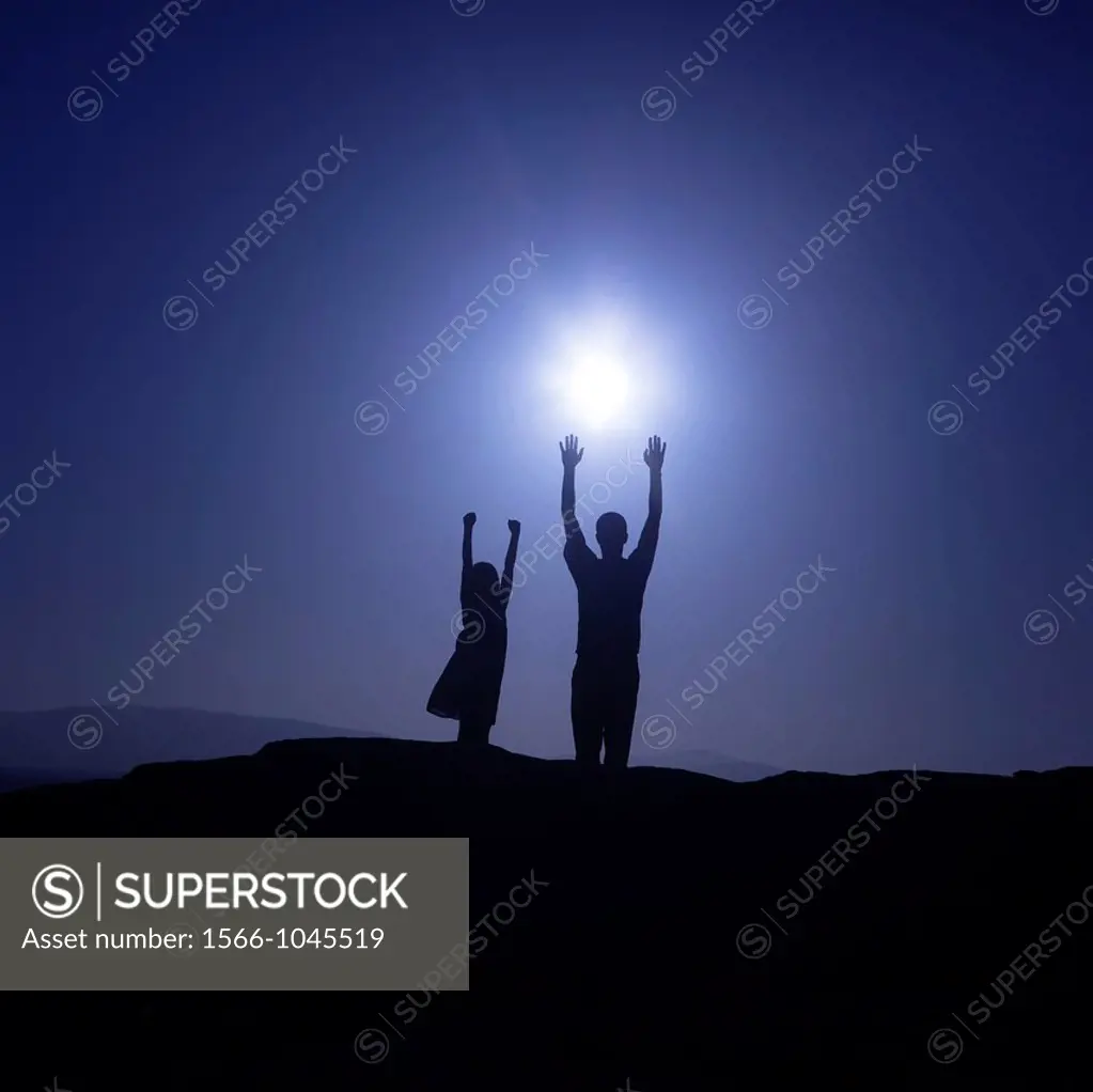 Father and daughter are reaching for the sun