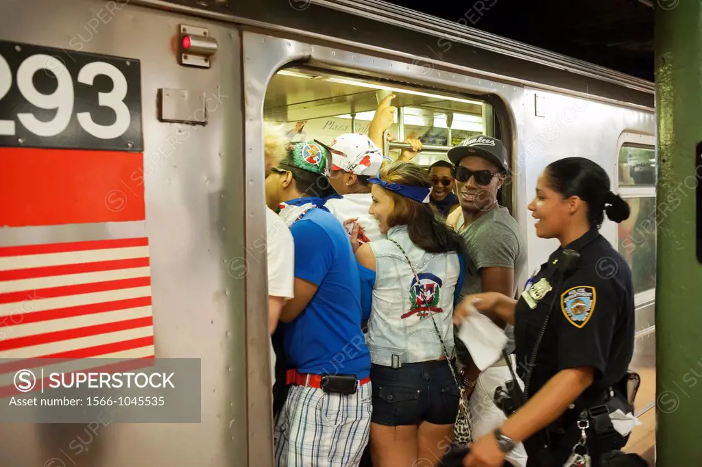 Revelers crowd the Number One train at the Columbus Circle station, traveling up to Washington Heights, after the Dominican Day parade in New