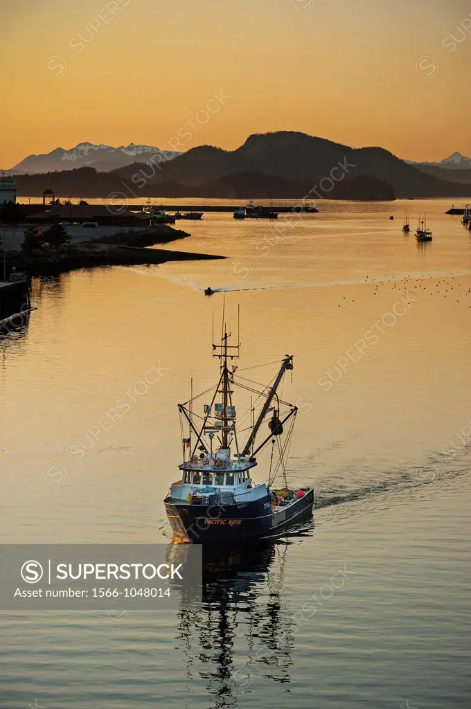 Commercial fishing vessel sailing through channel in Sitka, Alaska, USA