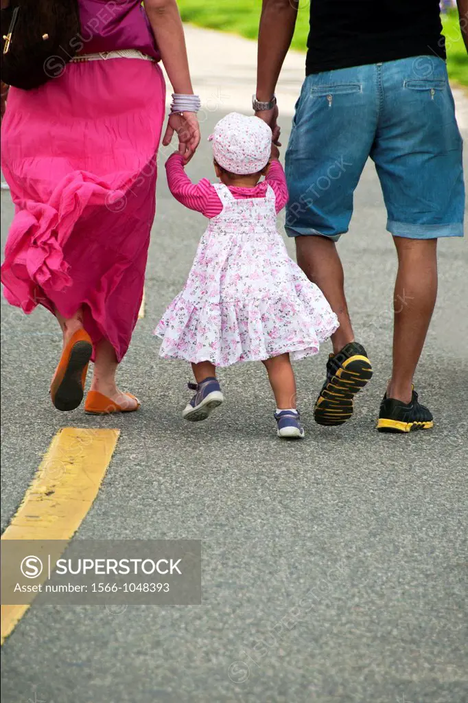 young parents with their little daughter on a walk, symbol of caring family