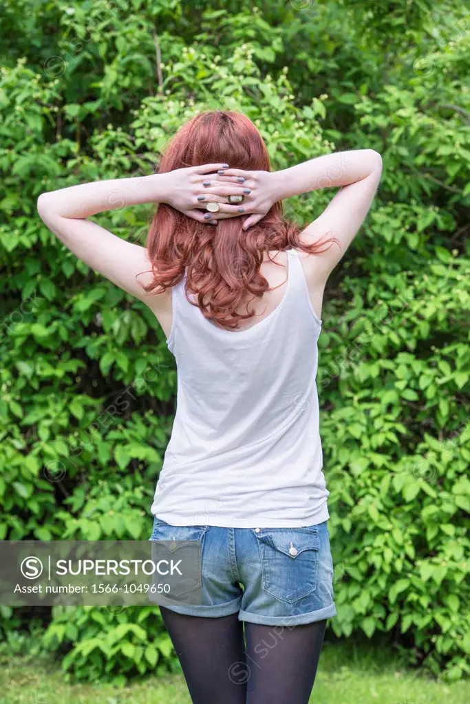 Back of young woman holding her hands behind her head