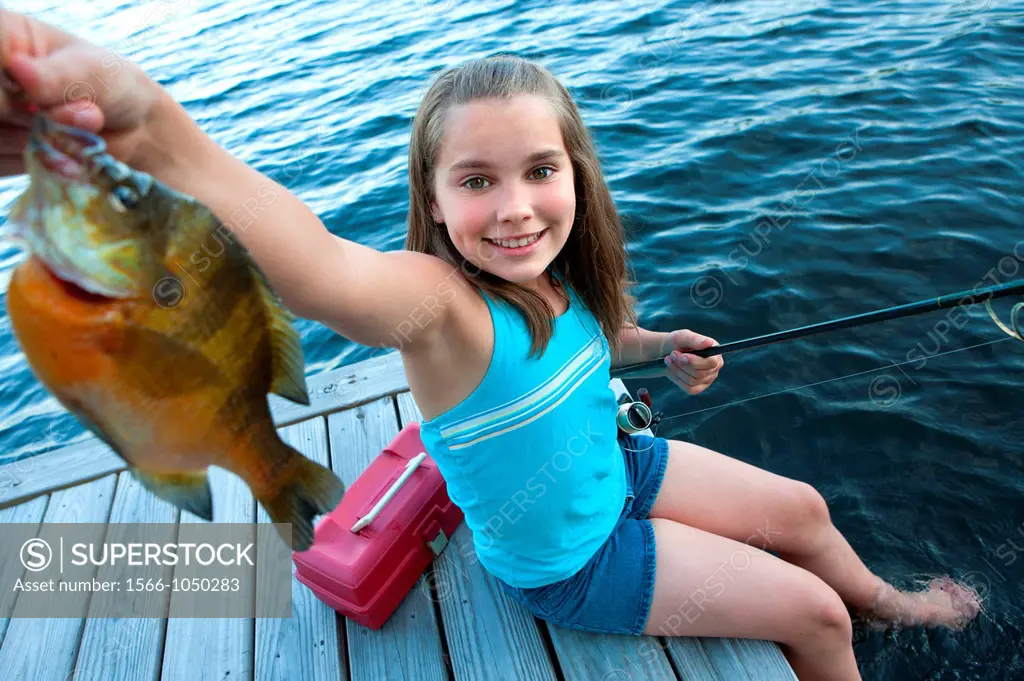 Young girl proudly shows off fish she caught