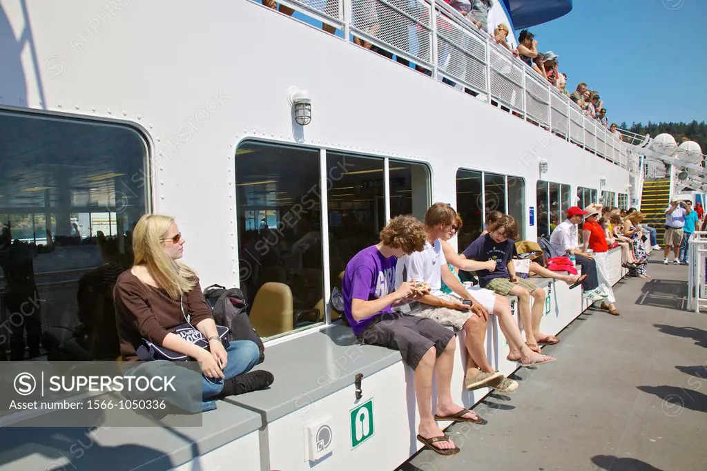 Passengers on the ferry to Victoria relaxing in the summer sun