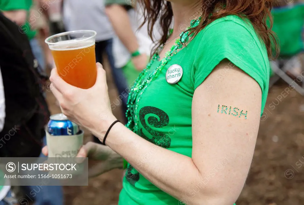A young woman with a beer in her hand and the word ´Irish´ affixed to her arm at a St  Patrick´s Day festival in Raleigh, North Carolina, USA