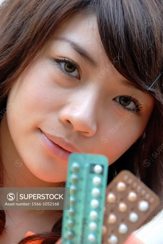 Young woman holding a blisterpack of oral contraceptive pills